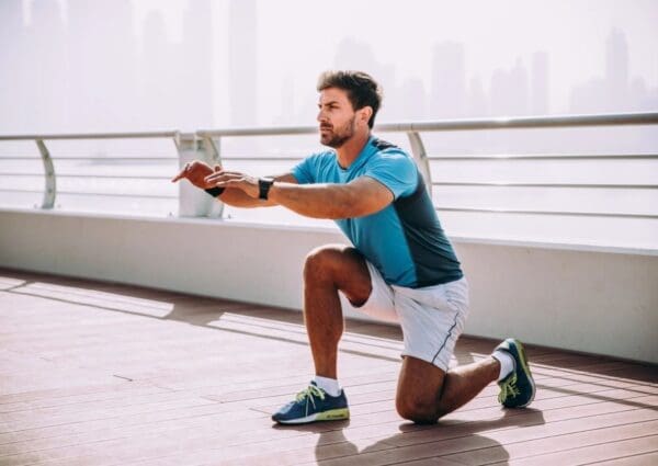 A man squatting on the ground in front of a city skyline.