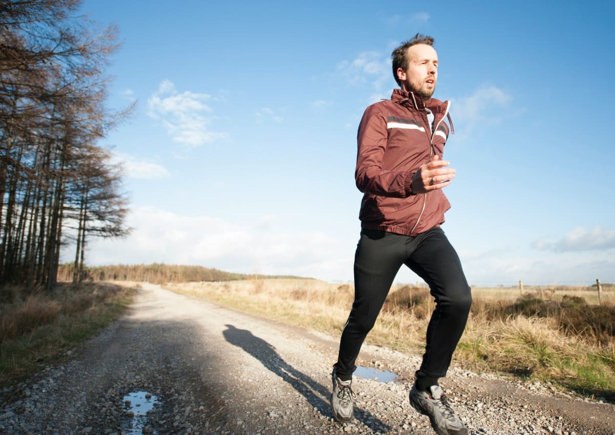 A man is running on the dirt road